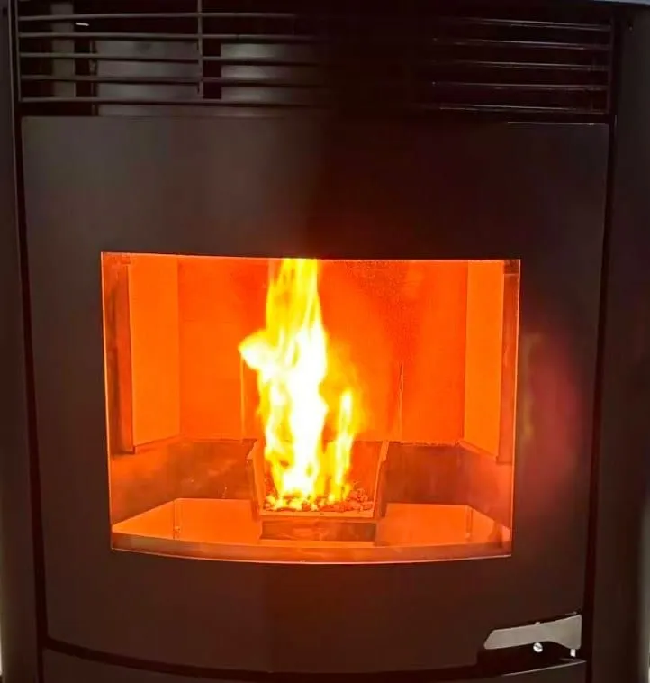 Pellet flame behind the curved glass of the round 15KW stove