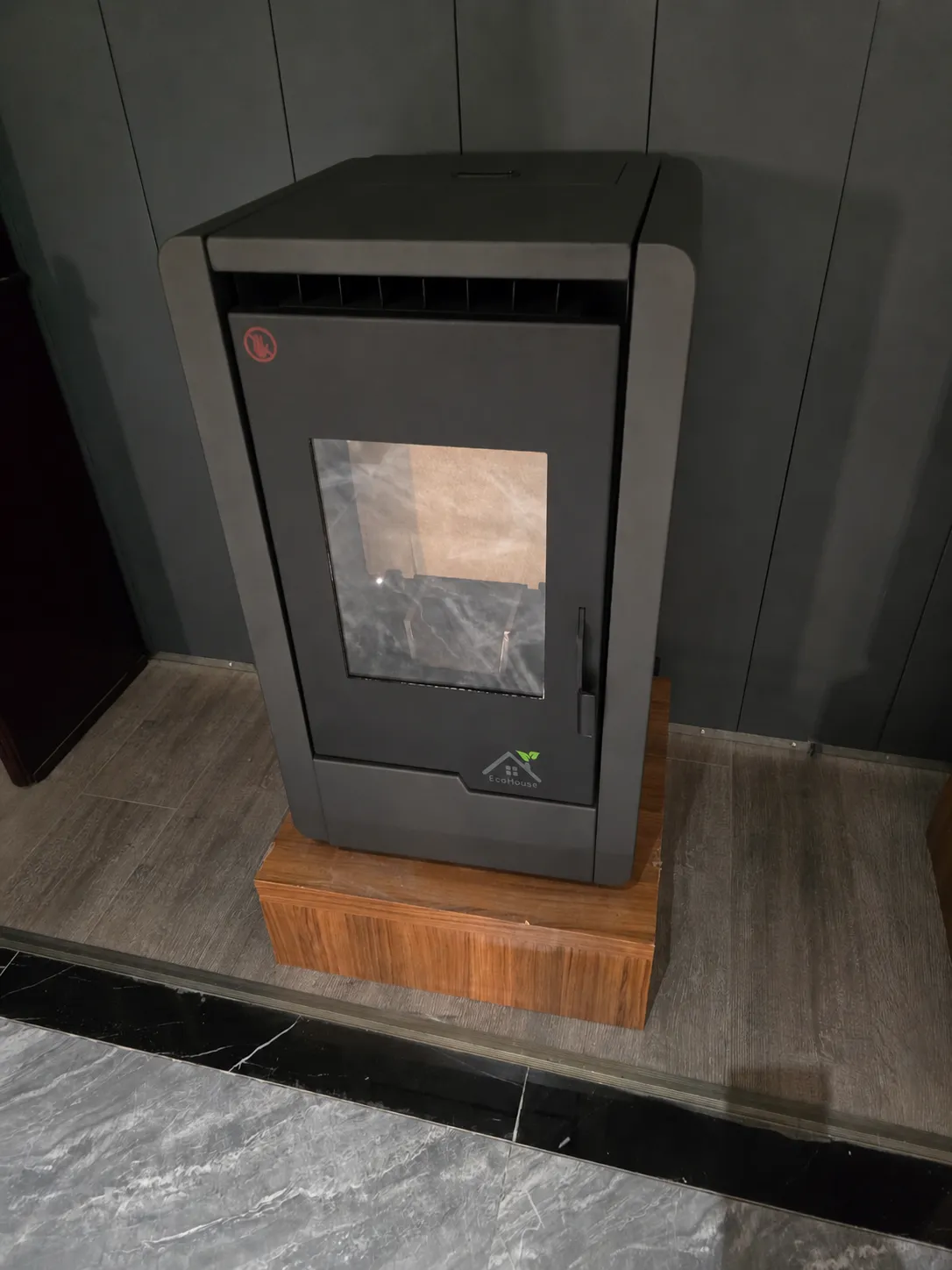 Matte graphite pellet stove against a stone wall